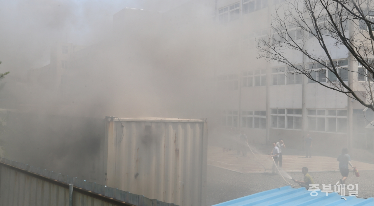28일 오후 1시 25분께 청주의 한 중학교 폐지보관 창고에서 화재가 발생한 가운데 선생님들이 초기 화재진압에 나서고 있다./신동빈