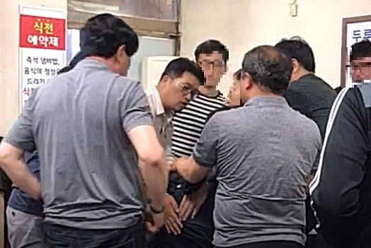 지난 25일 오후 청주의 한 식당에서 충북경찰청 소속 김용균 경정이 의식을 잃고 쓰러진 K씨를 살피고 있다. /독자제공