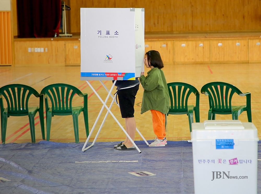 제19대 대통령선거일인 9일 투표소가 마련된 충북 청주시 청원구 율량동 제1투표소에서 유권자와 함께온 어린이가 엄마의 투표모습을 몰래 보고 있다. / 이정원