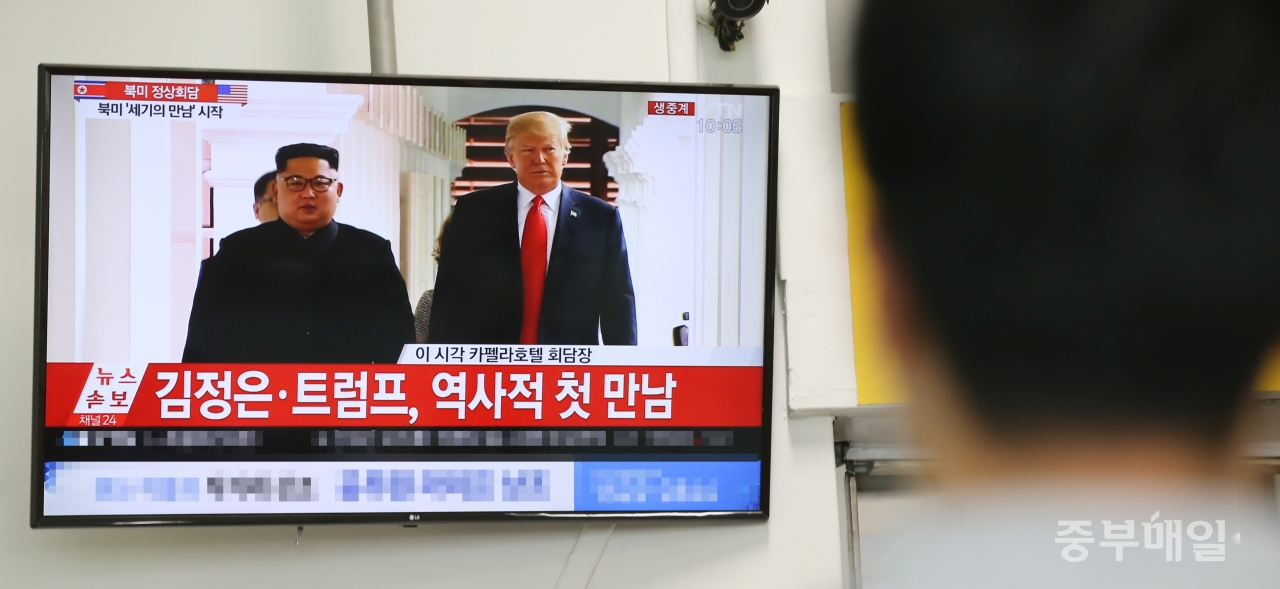 사상 첫 북미 정상회담이 열린 12일 청주 고속버스터미널에서 한 시민이 김정은 북한 국무위원장과 트럼프 미국 대통령이 회담장으로 걸어가는 모습을 지켜보고 있다./신동빈