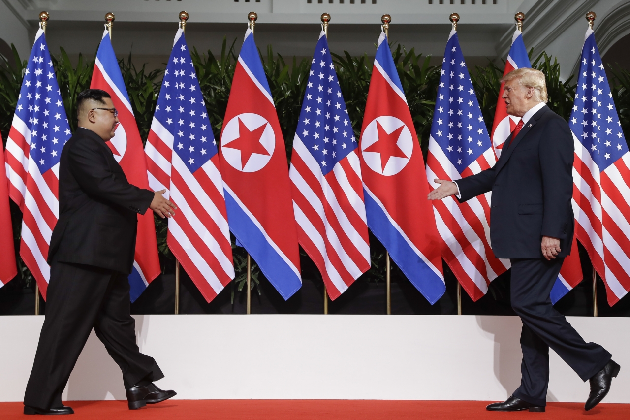 도널드 트럼프 미 대통령(오른쪽)과 김정은 북한 국무위원장이 12일 사상 첫 북미 정상회담이 열리는 싱가포르 카펠라 호텔에서 만나 악수를 위해 서로를 향해 걸어가고 있다. 2018.6.12 / 뉴시스