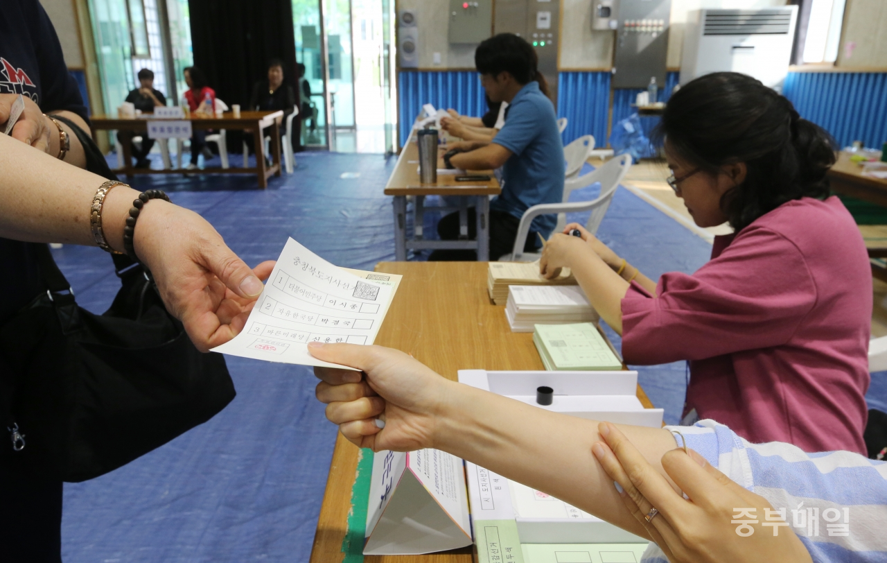 6.13 지방선거 투표일인 13일 청주 옥산초등학교에 마련된 투표소에서 유권자들이 투표용지를 받고 있다./신동빈
