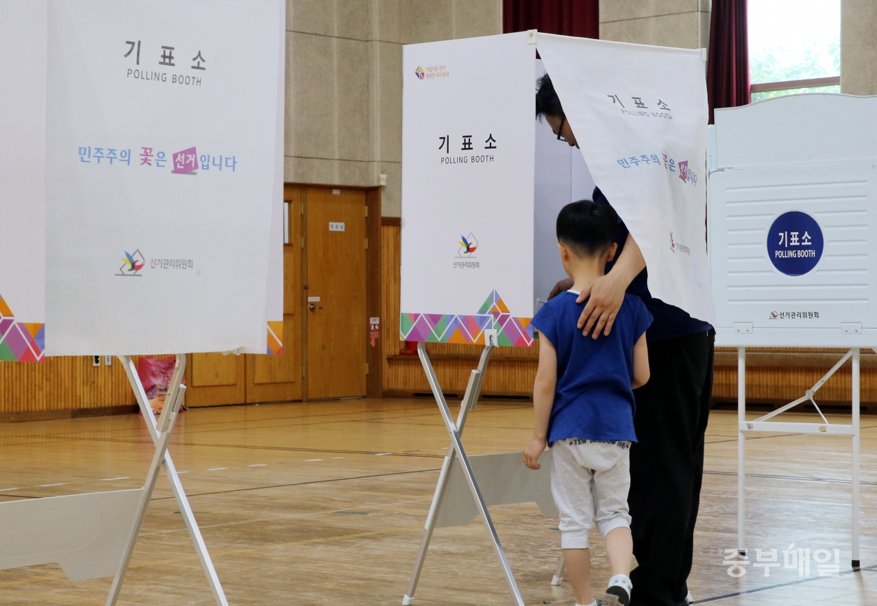 6.13 지방선거 투표일인 13일 청주 우암초등학교에 마련된 투표소를 찾은 한 아이가 아버지의 투표 모습을 지켜보고 있다./신동빈