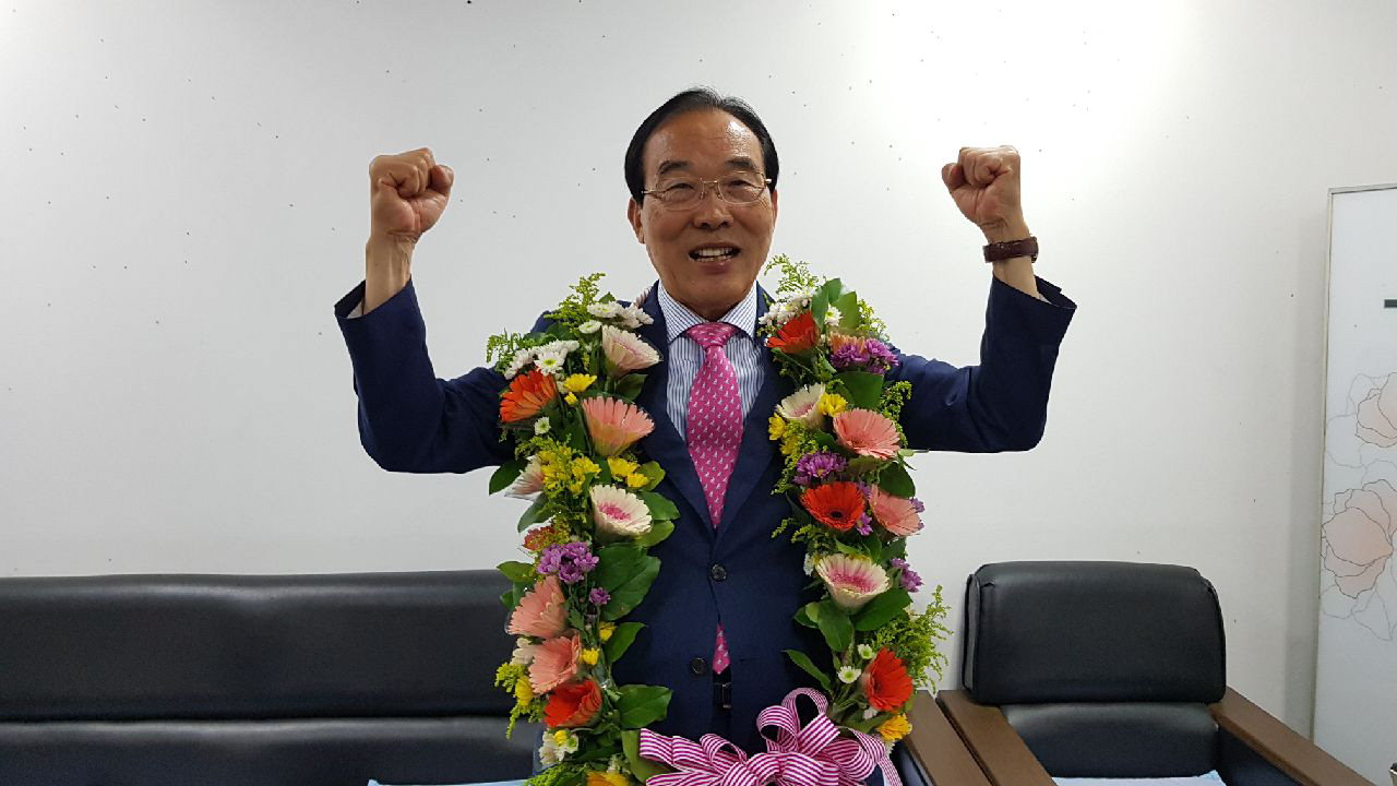 접전 끝에 3선에 성공한 정상혁 자유한국당 보은군수 당선인이 축하 꽃다발을 목에 걸고 환호하고 있다.