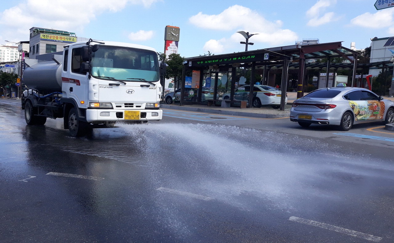 지역 업체가 운영하는 살수차가 뜨겁게 달궈진 아스팔트에 물을 뿌리고 있다. / 영동군청 제공