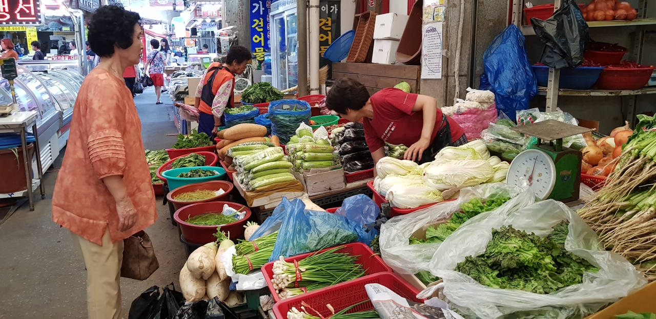 폭염이 연일 지속되고 있는 5일 청주 육거리 시장을 방문한 한 손님이 진열된 채소들를 유심히 살펴보고 있다. / 안성수