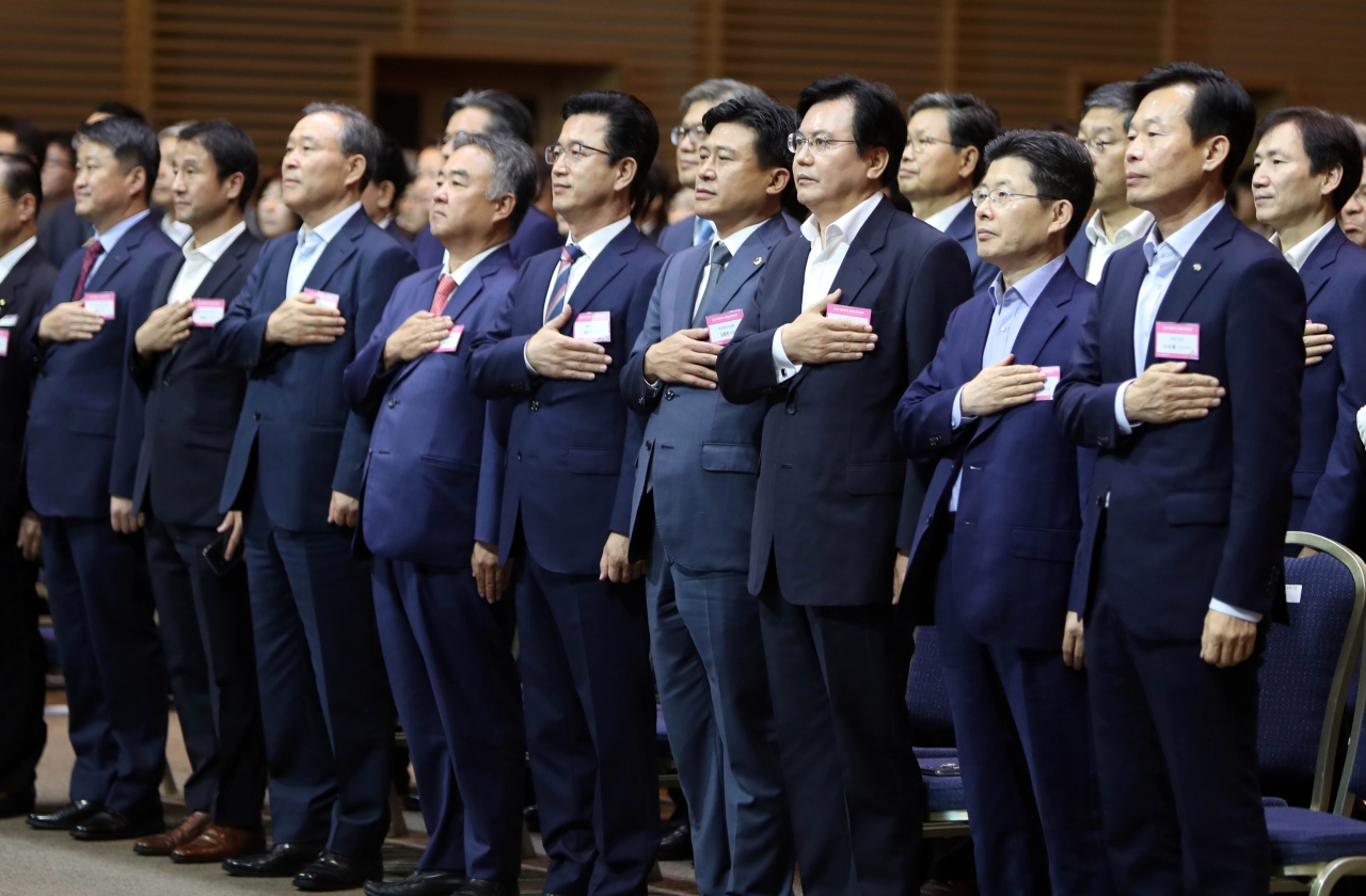 6일 대전에서 개막한 2018 대한민국 균형발전박람회에 참석한 시도지사 관계자들이 국기에 경례를 하고 있다.  / 연합뉴스