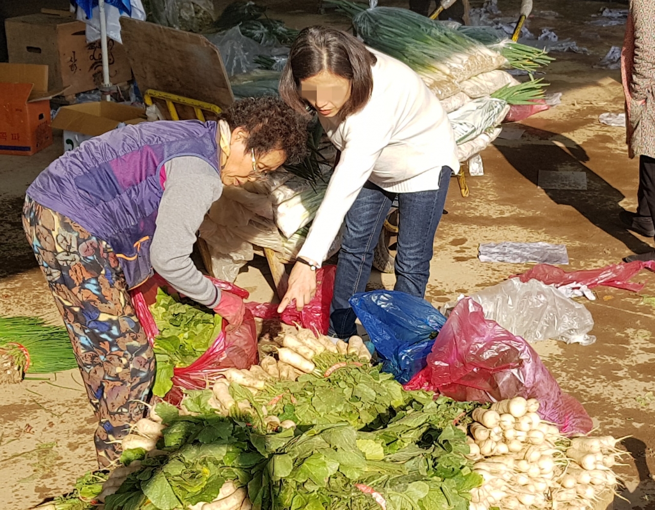 24일 청주농수산물도매시장을 방문한 소비자들이 김장에 쓰일 재료들을 유심히 살펴보고 있다. / 안성수