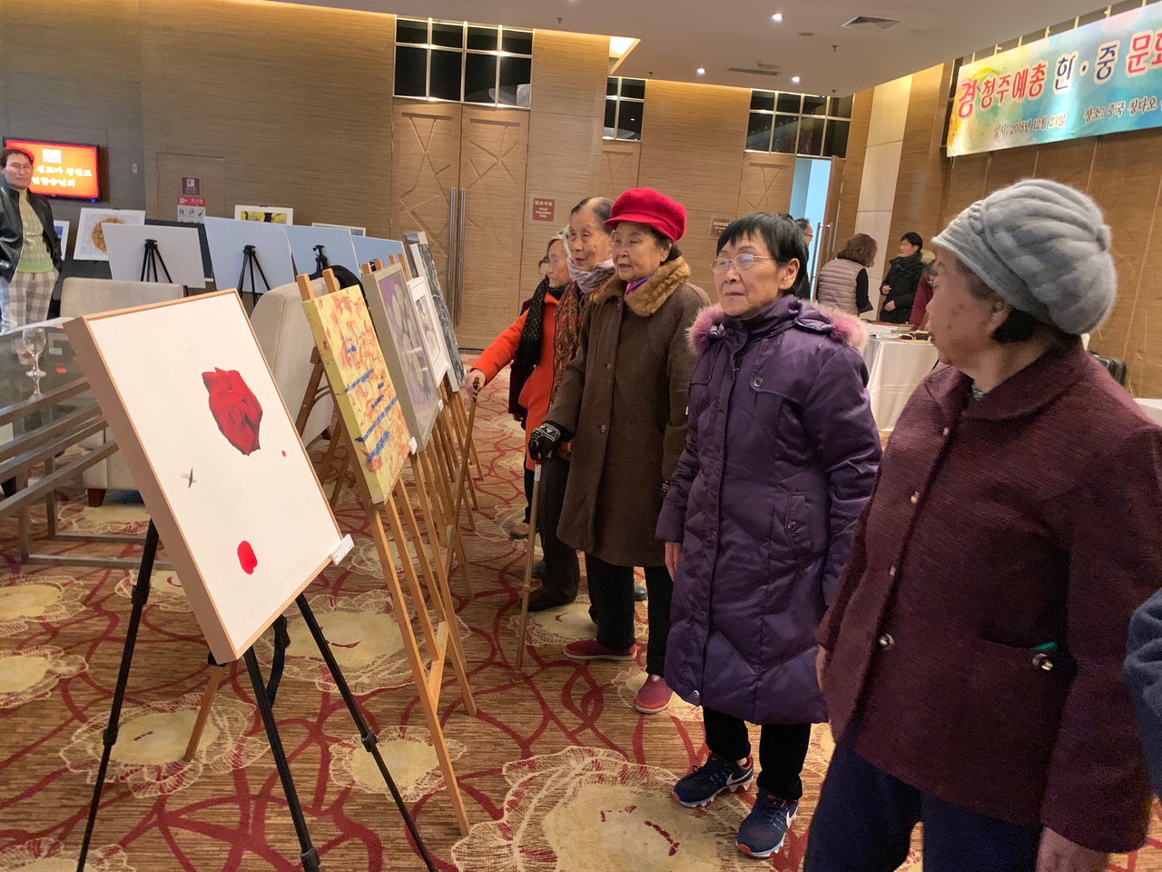 중국 칭다오 쉐라톤 호텔 로비에 마련된 청주예총 회원들의 작품을 보며 향수에 빠진 양문교 양로원 어르신들.
