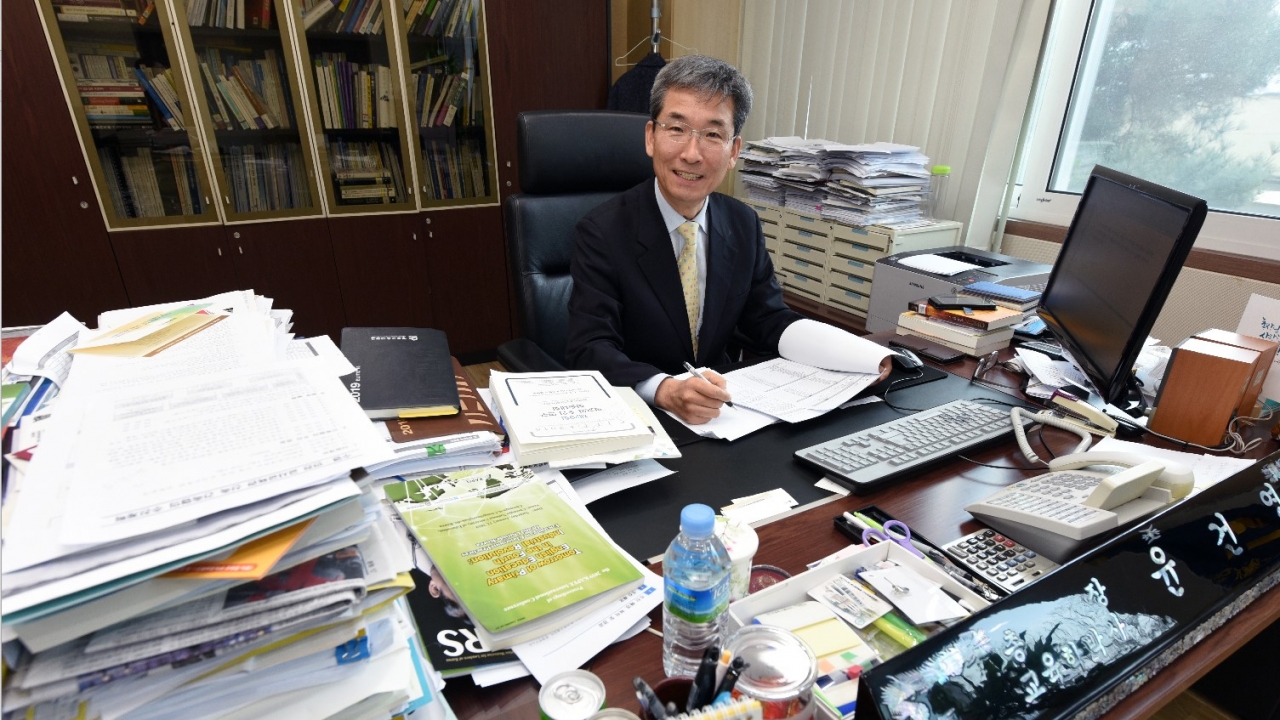 교원양성대학을 선도하고 있는 윤건영 청주교육대학교 총장이 많은 책이 쌓인 집무실 책상에서 업무를 보고 있다. / 김용수