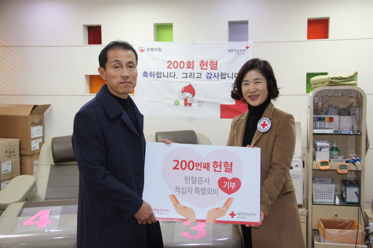 헌혈 200회를 달성한 조호국(왼쪽)씨가 대한적십자사에 헌혈증서 100장과 성금 200만원을 전달하고 있다. /대한적십자사 충북혈액원