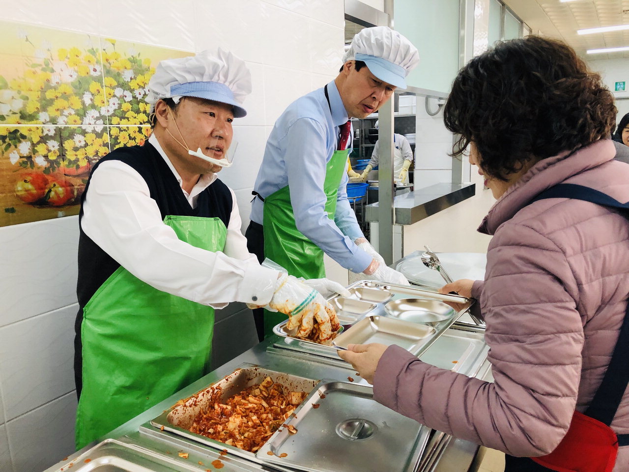박종만 농협 진천군지부장이 21일 생거진천종합사회복지관 식당에서 어르신들에게 점심을 배급하고 있다.