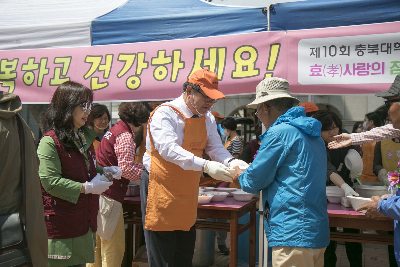 김수갑 충북대 총장이 8일 청주 중앙공원에서 어르신에게 점심을 나눠주고 있다. / 충북대학교 제공<br>