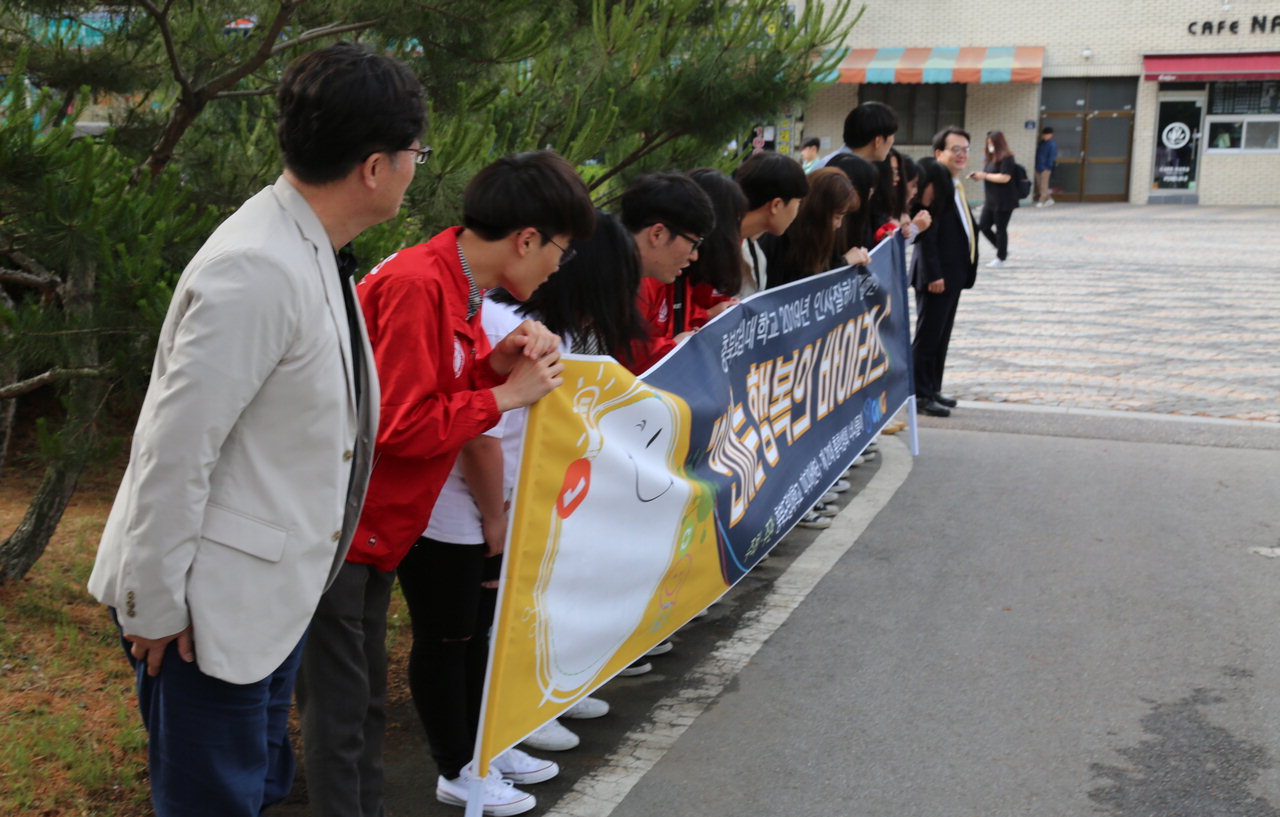 28일 충북도립대학교 학생들이 직접 제작한 현수막을 들고 인사 잘하기 캠페인을 하고 있다. / 충북도립대학교
