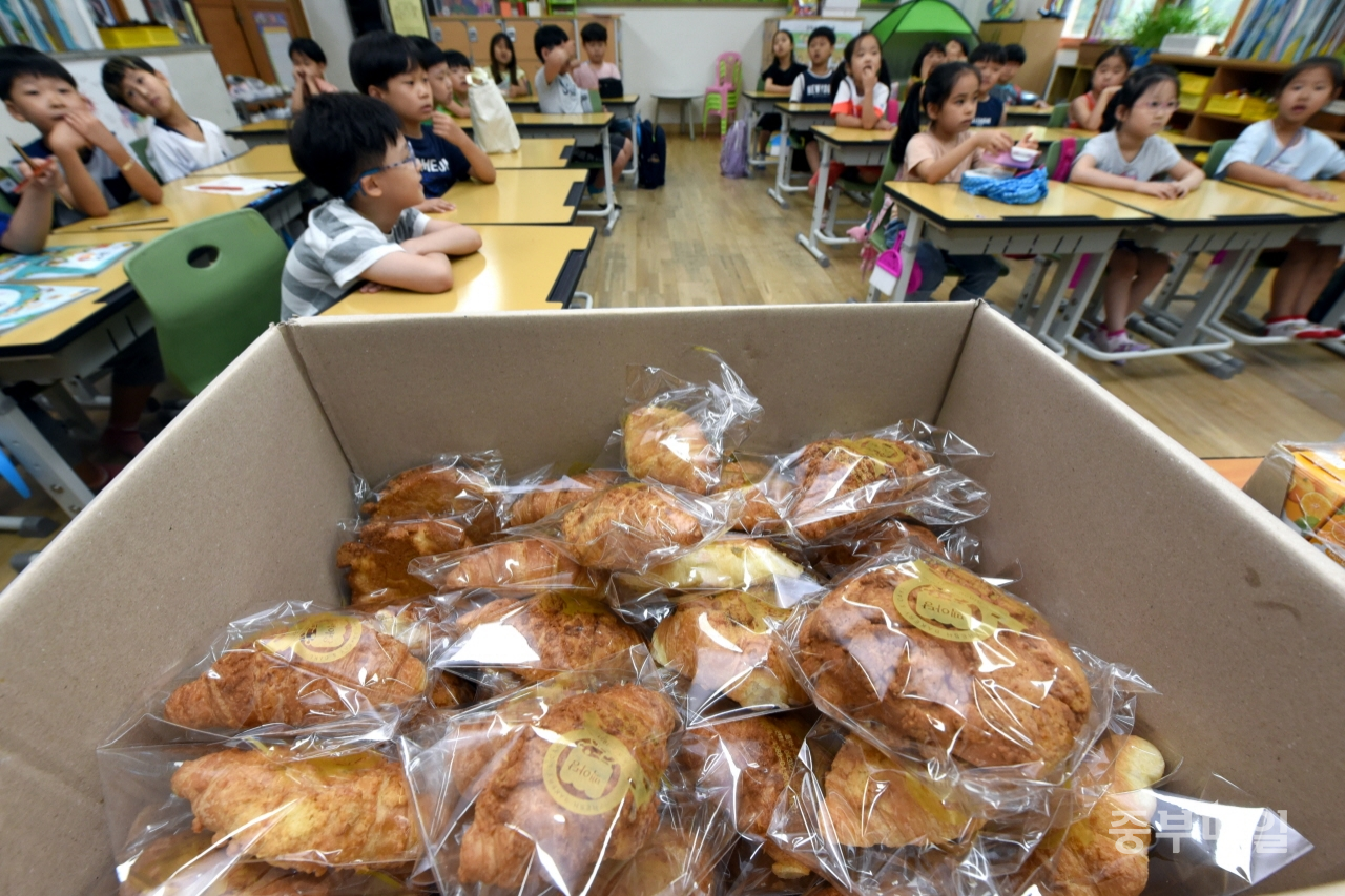 학교비정규직연대회의가 총파업에 들어간 3일 급식이 중단된 청주 성화초등학교 1학년 학생들이 대체급식으로 나눠준 빵을 먹고 있다. / 김용수