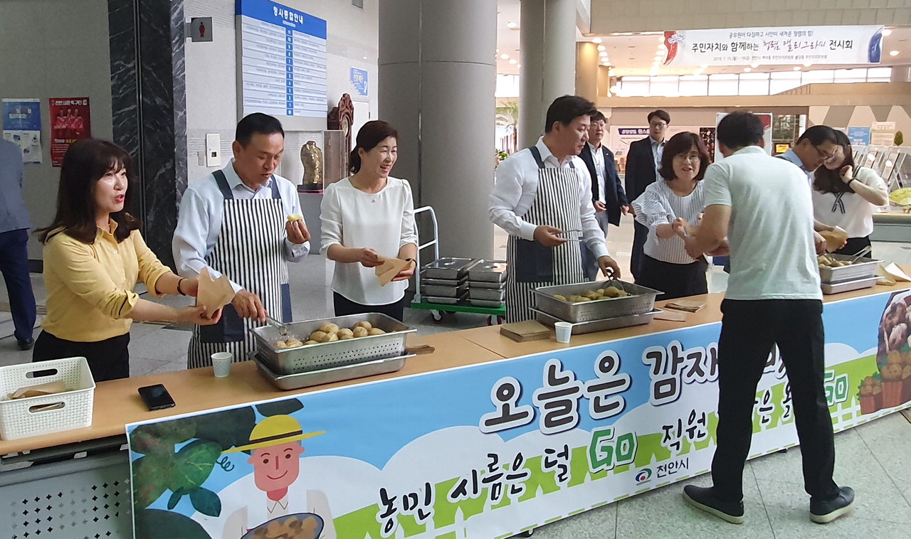 15일 구본영 천안시장이 시청 로비에서 직원들에게 찐 감자를 나눠주고 있다./천안시 제공