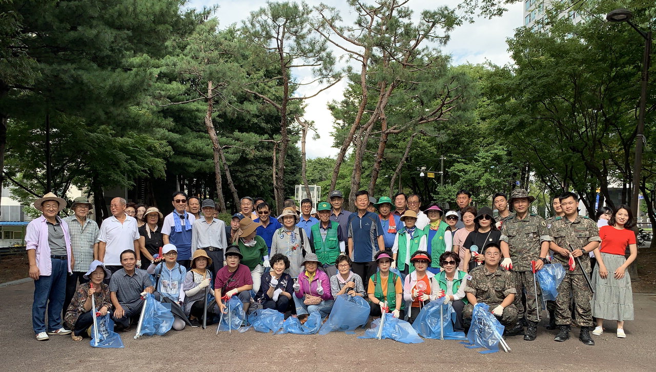 지난 14일 광복절을 맞이해 신안동 직원들과 자생단체원들 50여명이 마을 대청소를 실시하고 있다. /천안시 제공