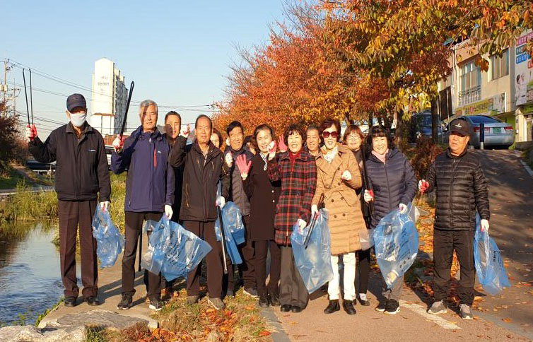 천안시 원성2동 통장협의회가 20일 매달 개최하는 월례회의를 원성천변에서 진행하며 환경정비를 하고 있는 모습. /천안시 제공