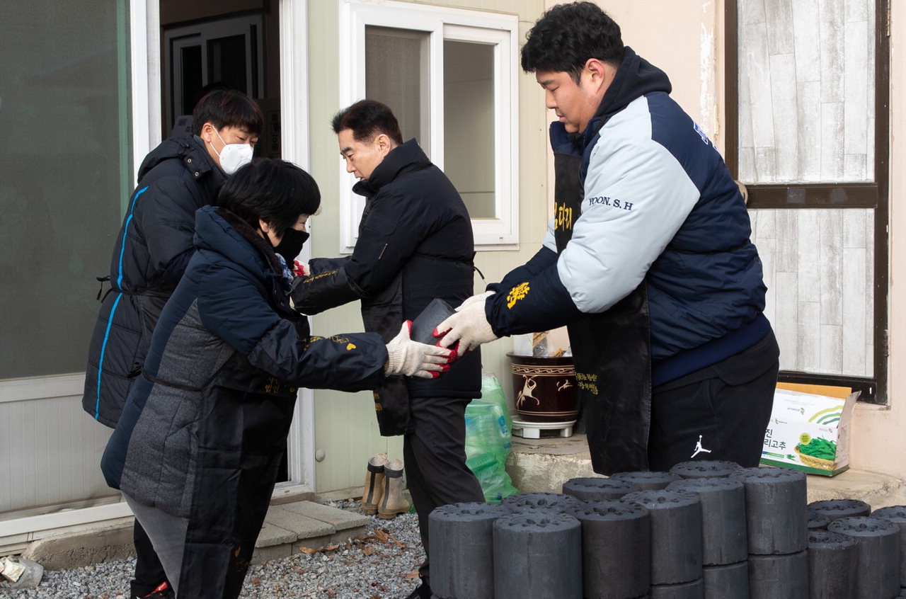 인삼씨름단 선수들과 증평군체육회 직원들이 7일 저소득층가구를 찾아 연탄을 나르고 있다.