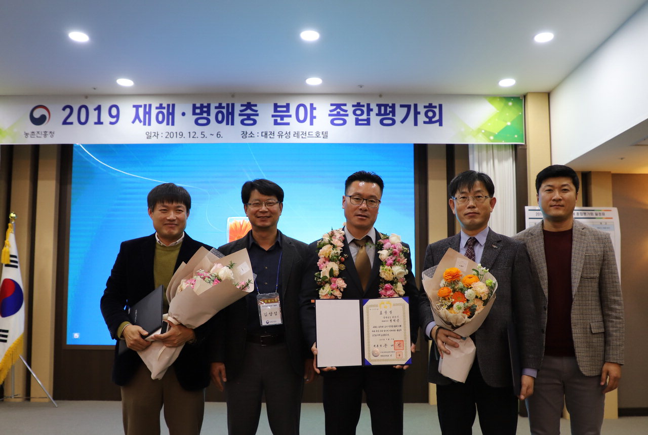 천안시농업기술센터 정억근(45) 과수팀장(가운데)이 식물방제 유공으로 대통령 표창을 받아 기념사진을 찍고 있다. /천안시 제공