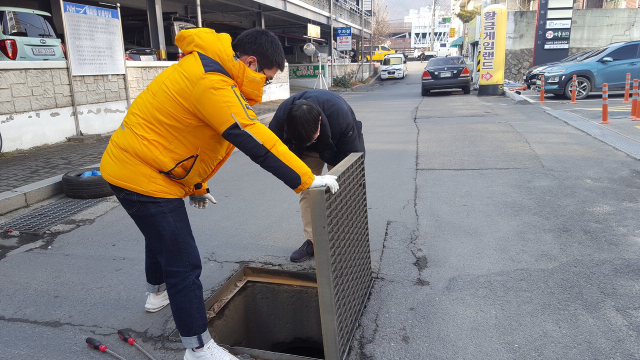 보건소 담당자들이 맨홀안에 유충구제제를 투약하고 있다. 윤여군 / 옥천