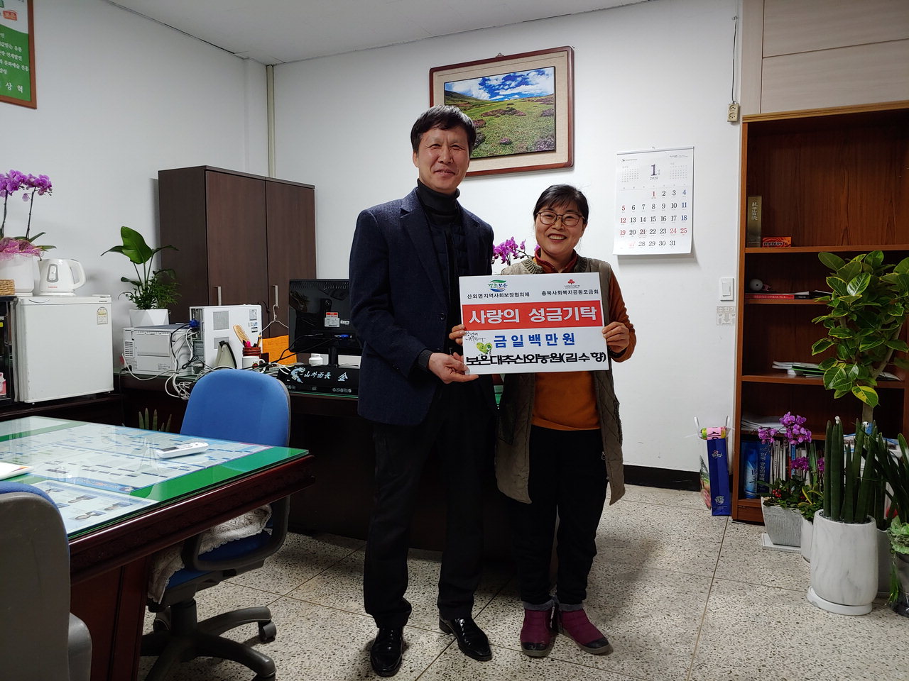김영제(왼쪽) 면장과 김수향 보은대추산외농원 대표가 성금 기탁식을 진행하고 있다. / 보은군 제공