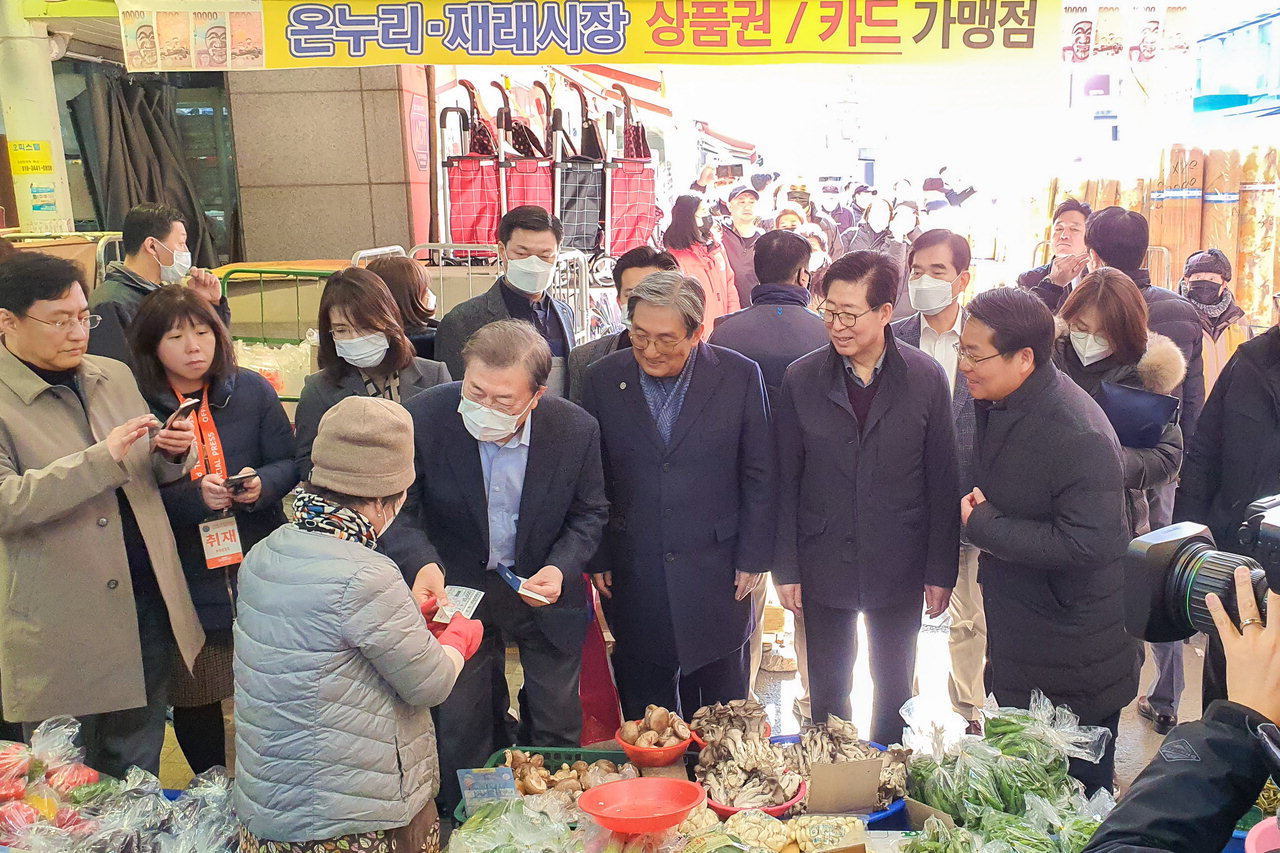 오세현 아산시장이 문재인 대통령과 함께 온양온천전통시장을 방문해 아산사랑상품권으로 채소와 만두 등을 구입하고 있다.