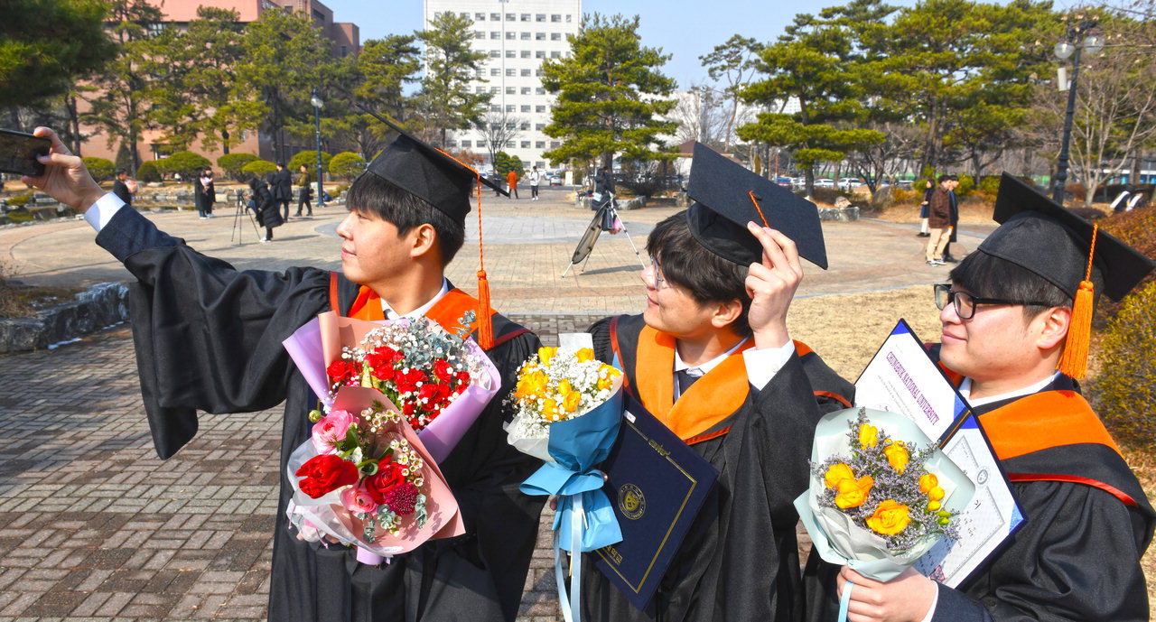 20일 코로나19 여파로 충북대학교 졸업식은 취소됐으나 졸업생들이 학사모를 쓰고 기념사진을 찍으며 추억을 남기고 있다. / 김용수