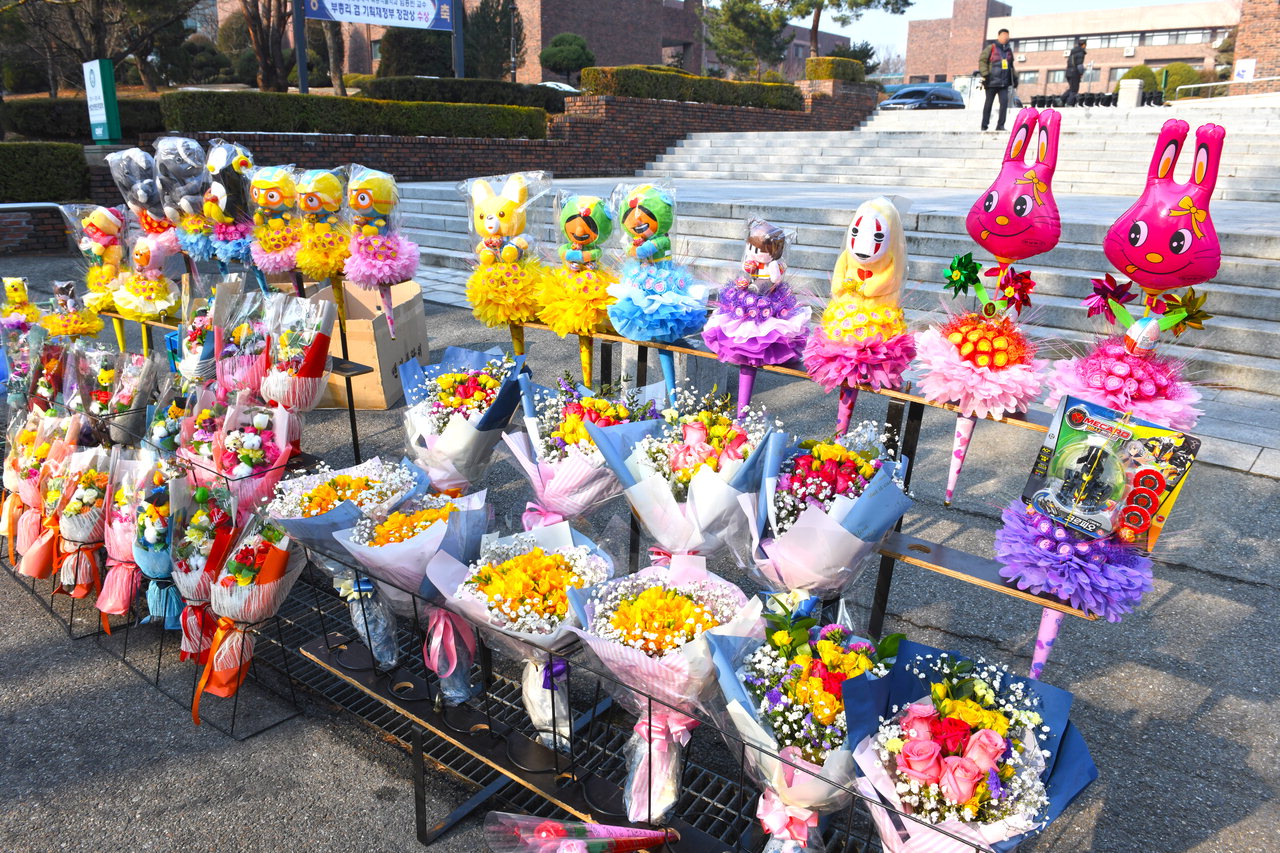 20일 코로나19 여파로 충북대학교 졸업식이 취소된 가운데 일부 졸업생들이 학사모를 쓰고 기념사진을 찍기 위해 학교에 나왔으나 꽃 판매상들은 '개점휴업'상태다. / 김용수