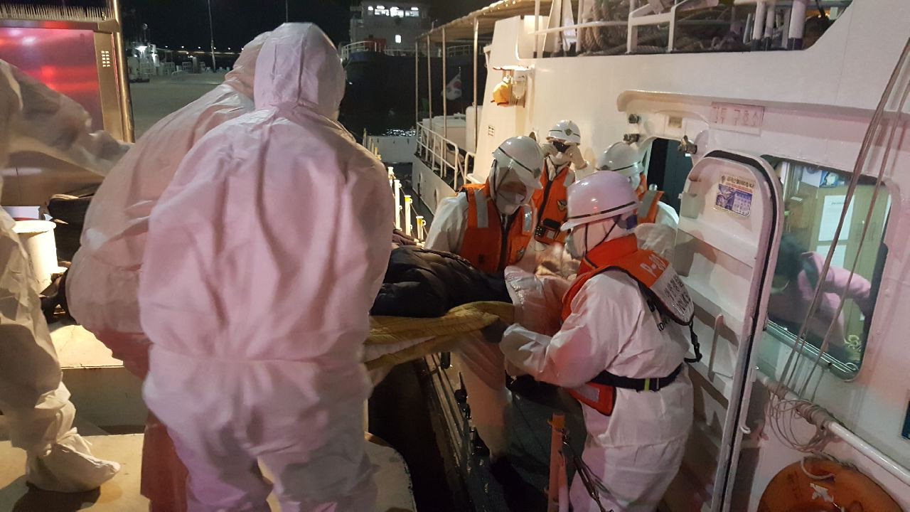 대천항으로 이송된 고열 증상 환자가 119대원들에게 인계되고 있다. / 보령해양경찰서 제공
