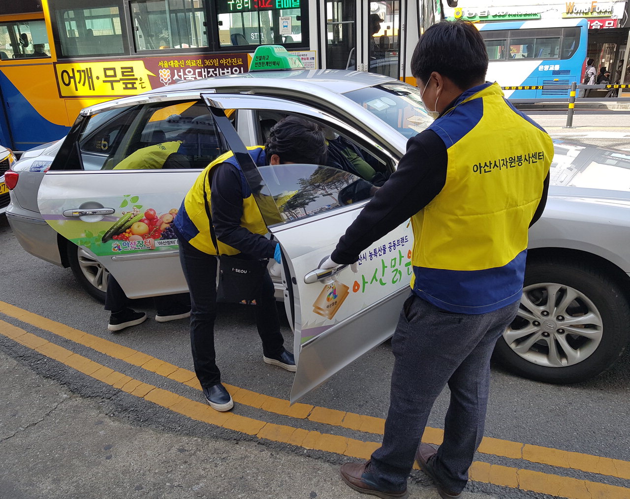 아산시 자원봉사자들이 소독제를 사용해 택시 내외부 손잡이를 일일이 닦아내고 있다. / 아산시 제공