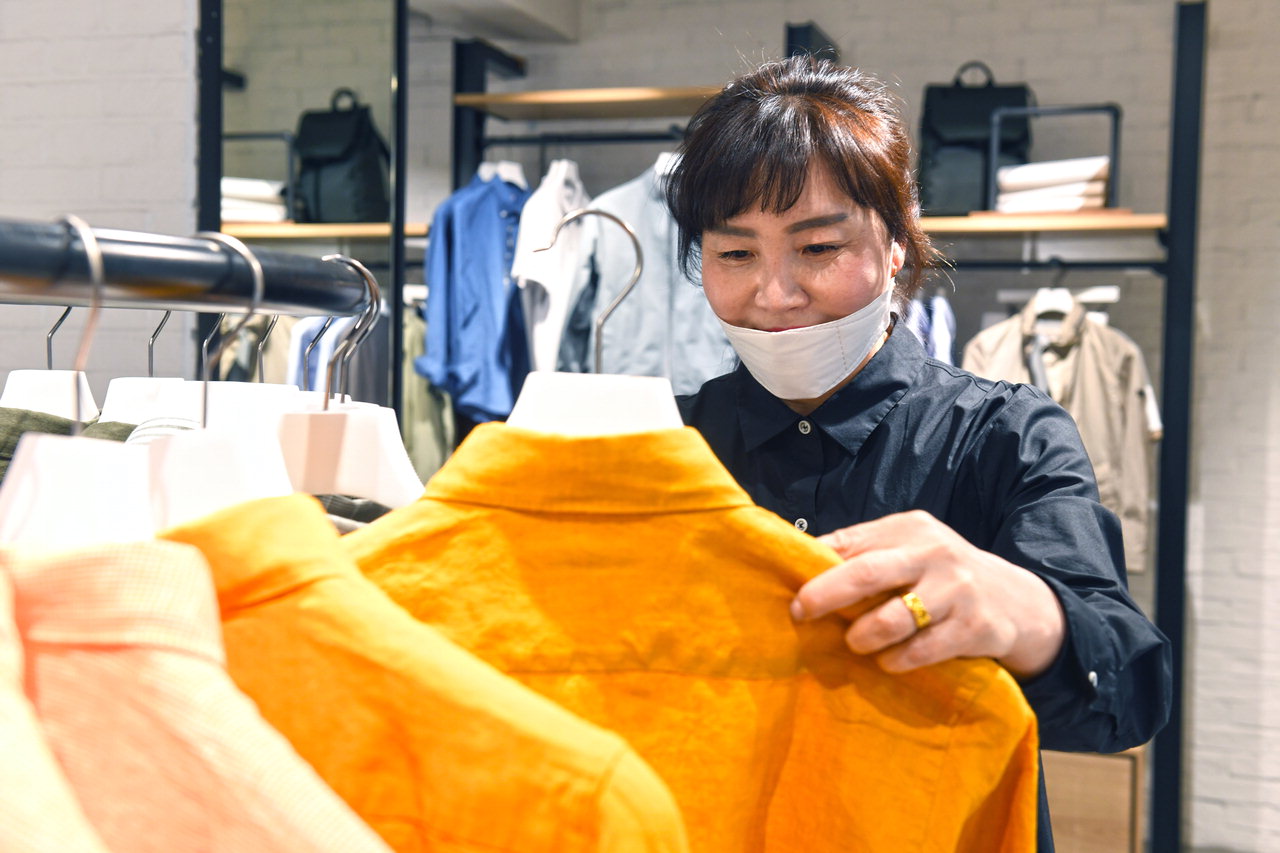 청주 도심상가에서 25년 동안 근무하고 있는 조선자 점장이 매장에서 의류 상품을 정리하고 있다. / 김용수