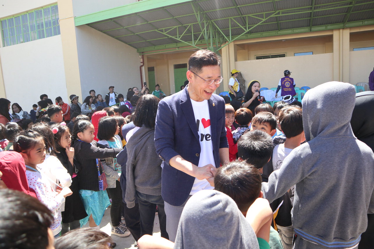 김완호 총재가 필리핀 학생들과 손을 잡고 이야기를 나누고 있다. / 국제라이온스클럽 356-D(충북)지구 제공