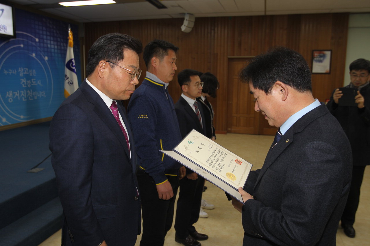 왕용래 회장이 2018년 송기섭 진천군수에게 산업발전 유공 우수기업인 표창을 받고 있다.