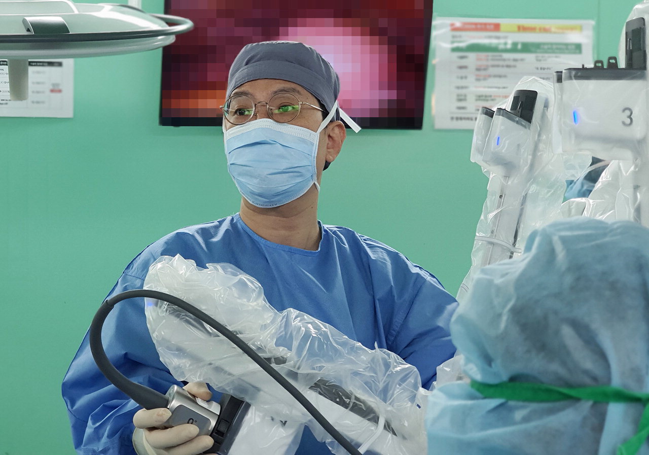 건양대병원 산부인과 김철중 교수가 로봇수술 집도를 위해 로봇팔을 환자의 수술부위에 도킹하고 있다. / 건양대병원 제공