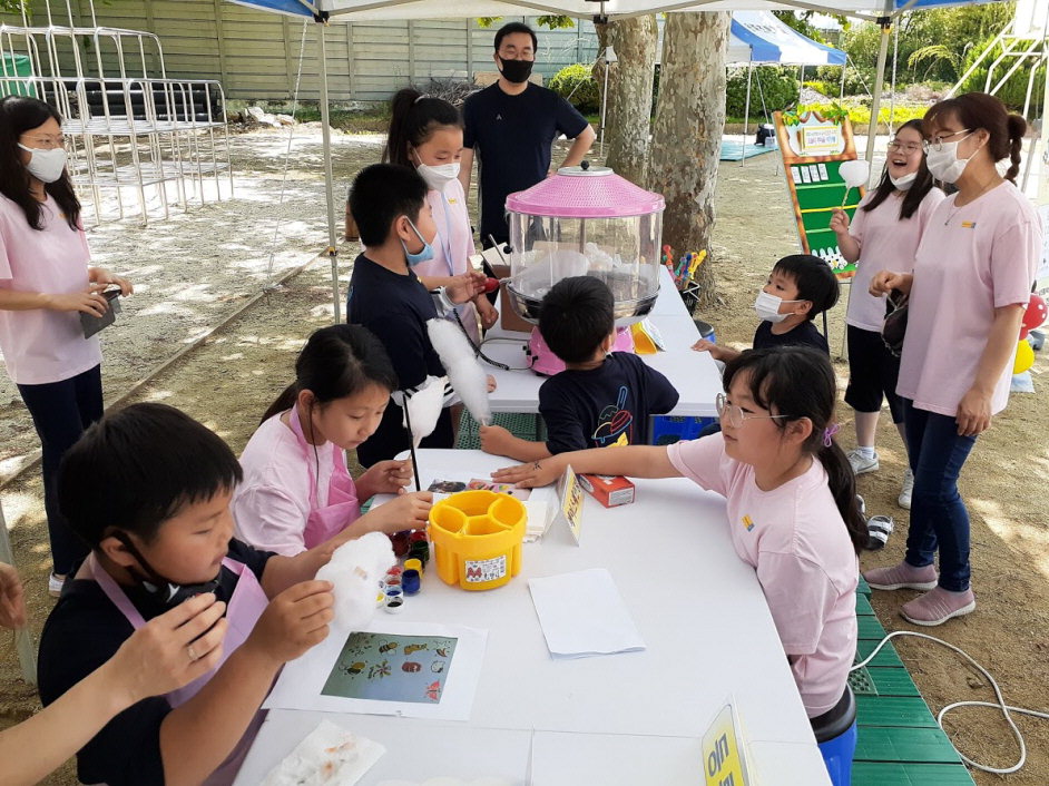 사진전시회에 참여한 보은 송축초 학생들이 사진 전시 작업과 솜사탕 먹기 활동을 하고 있다. / 보은교육지원청 제공