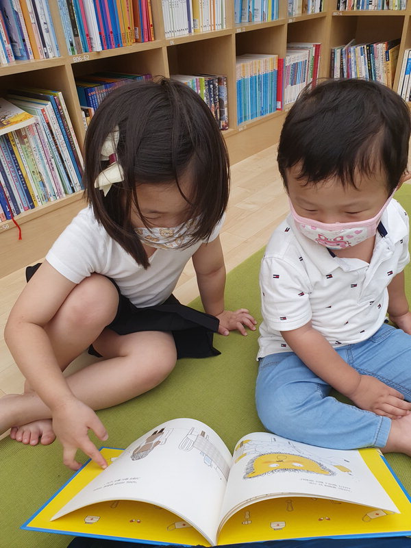 어린이들이 중고서점에서 그림책을 보고 있다.