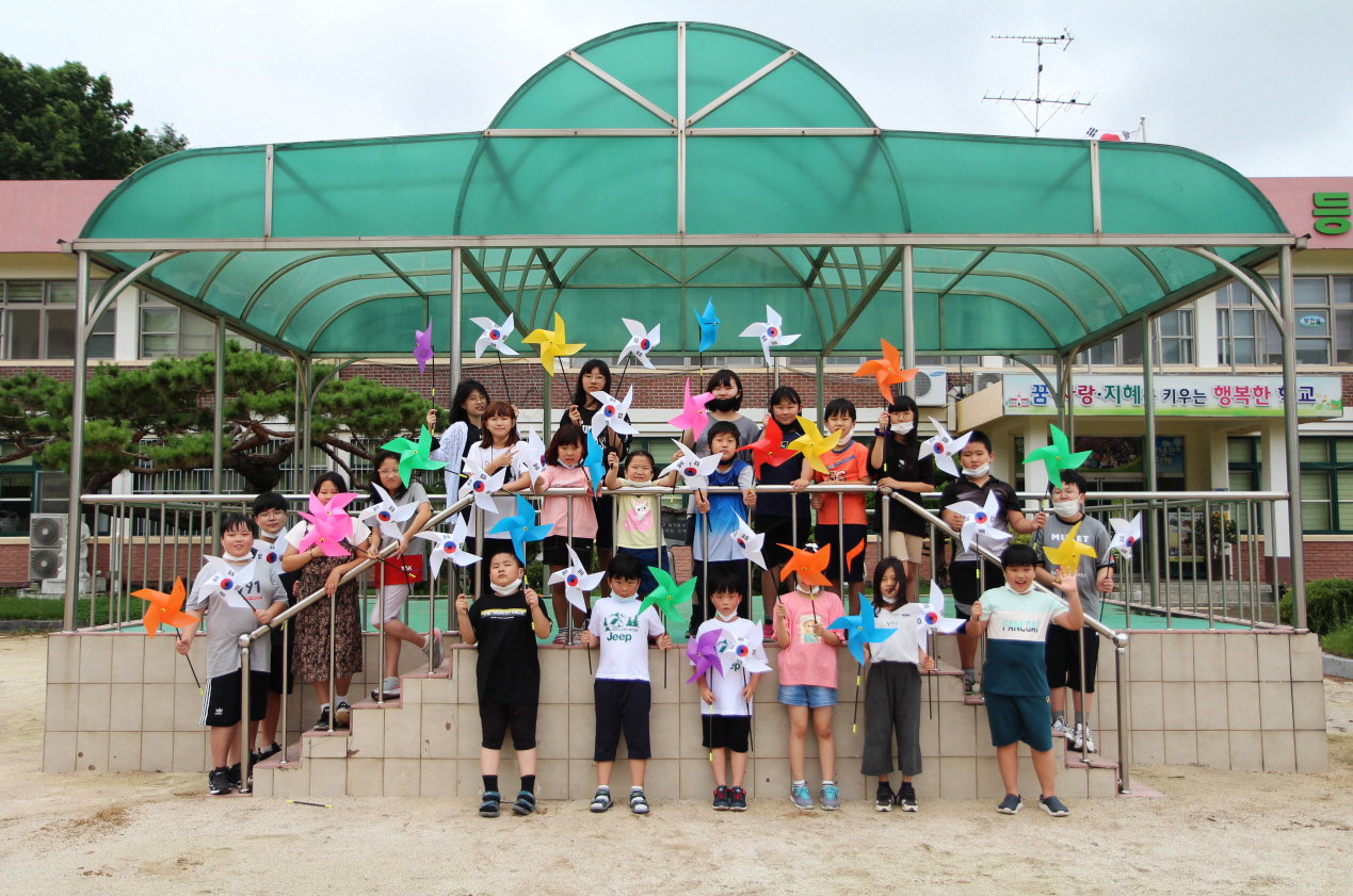 탄부초 학생들이 직접 만든 통일 바람개비를 들고 기념사진을 찍고 있다. / 보은교육지원청 제공