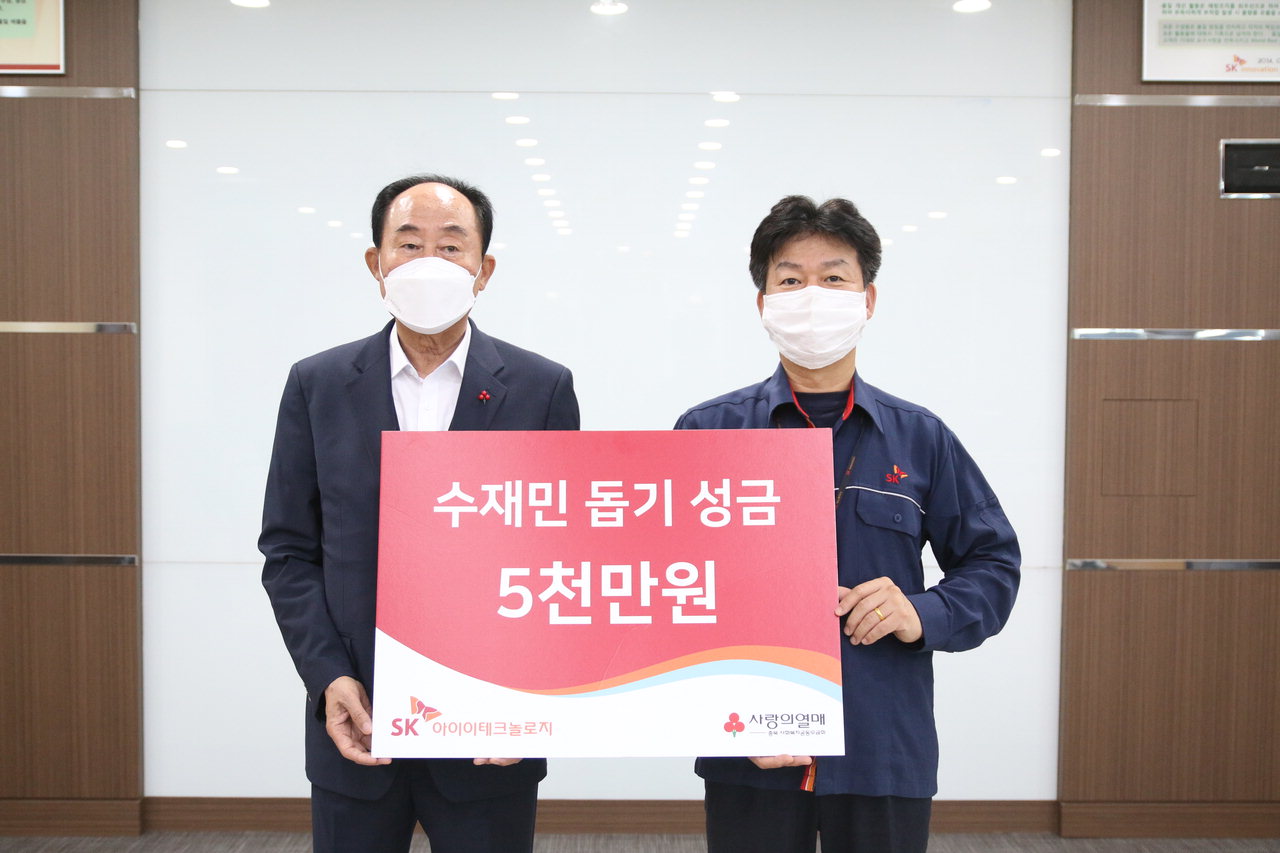 이수행 SK아이이테크놀로지 공장장이 12일 노영수 충북사회복지공동모금회장에게 충북지역 호우 피해 이재민을 위한 수재의연금 5천만원을 전달하고 있다.