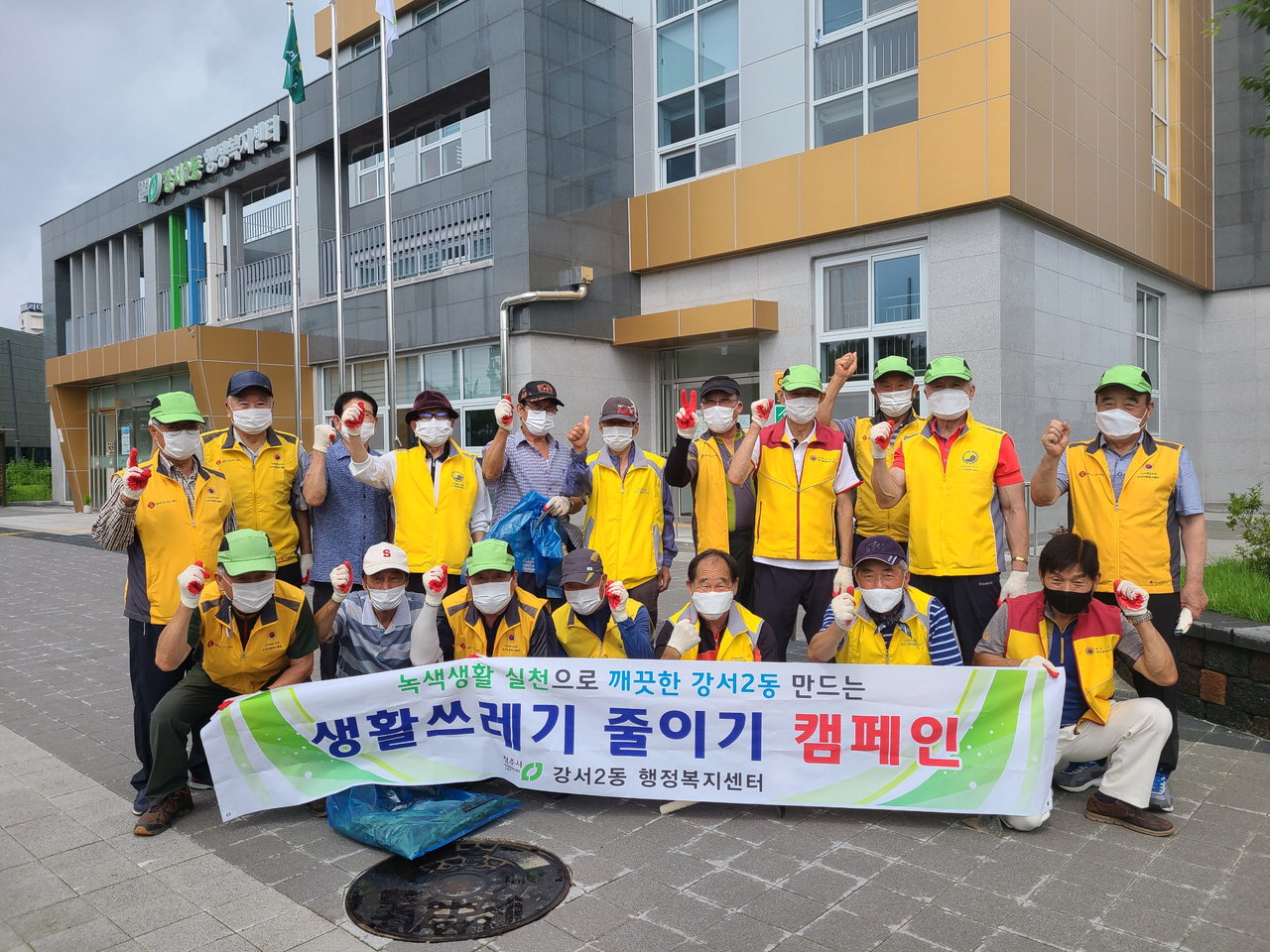 강서1동 노인회 회원 20여 명이 행정복지센터 주변 청소 봉사를 실시한 뒤 단체사진을 찍고 있다.