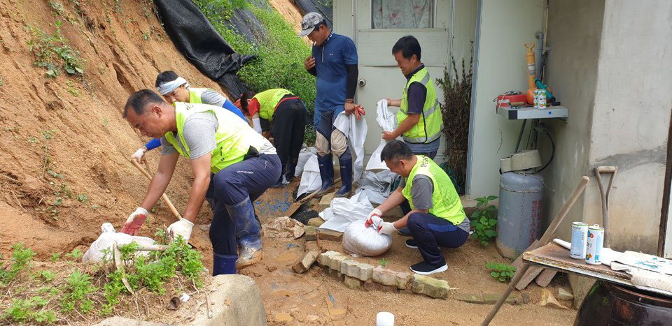 내수읍 자율방범대원들이 폭우 피해를 입은 저소득노인 가구의 수해복구를 돕고 있다.