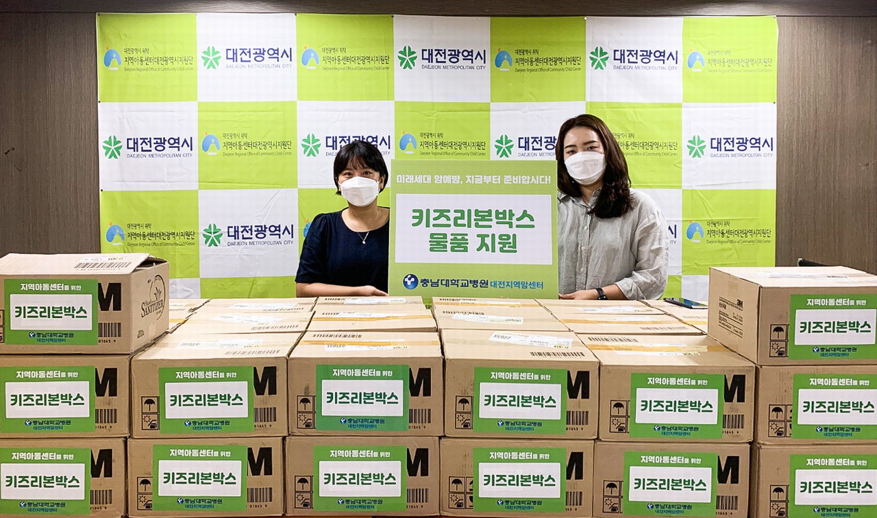 충남대병원 대전지역암센터가 지역아동센텉대전광역시지원단에 키즈리본 박스를 전달하고 있다. / 충남대병원 제공