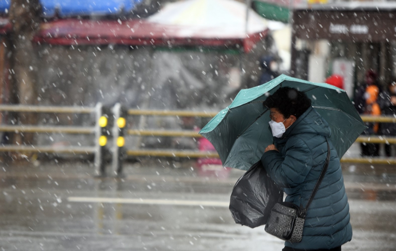 충북도내에 강풍을 동반한 폭설이 내린 28일 청주시 상당구의 거리에서 한 시민이 우산으로 눈보라를 막으며 지나가고 있다. /김명년