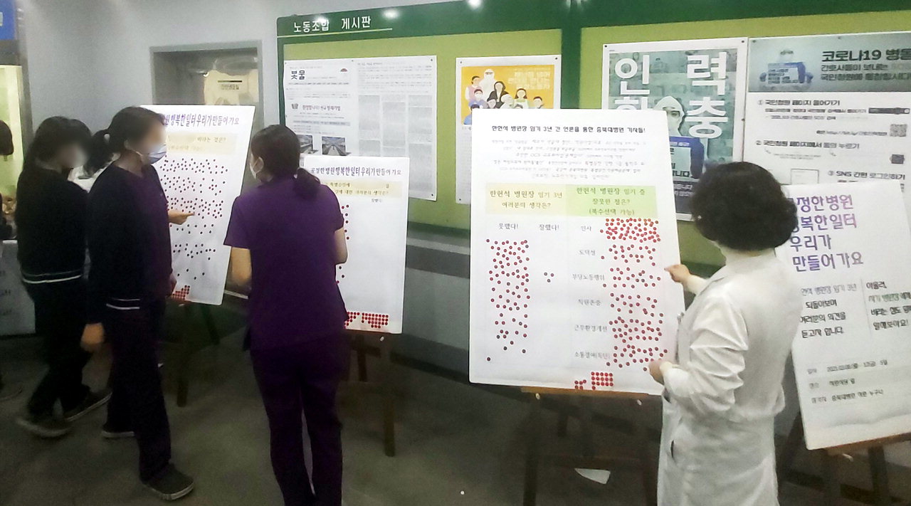 충북대병원 직원들이 8일 직원식당 앞에서 한헌석 병원장 등에 대한 설문조사에 참여하고 있다. /신동빈