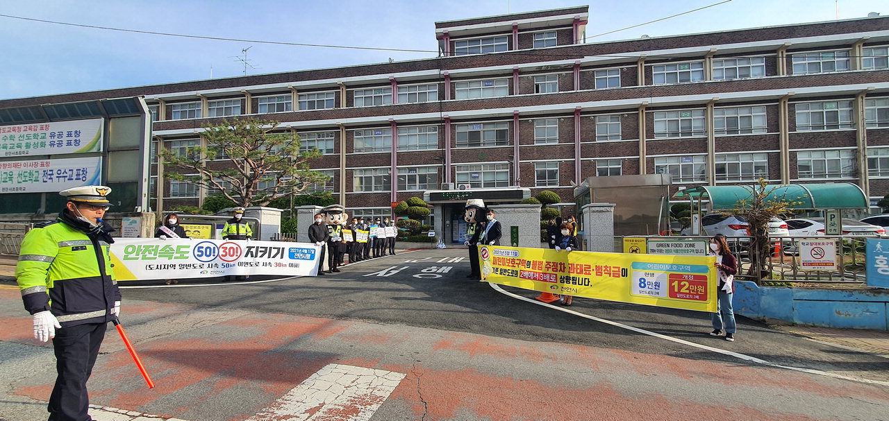 천안시가 15일 서초등학교 앞에서 방역수칙을 준수한 가운데 교통안전 캠페인을 펼치고 있다./천안시 제공