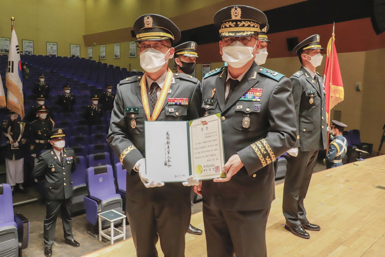 육군참모총장상을 받은 전일혁 준위가 정재학 육군학생군사학교장과 기념촬영을 하고 있다.