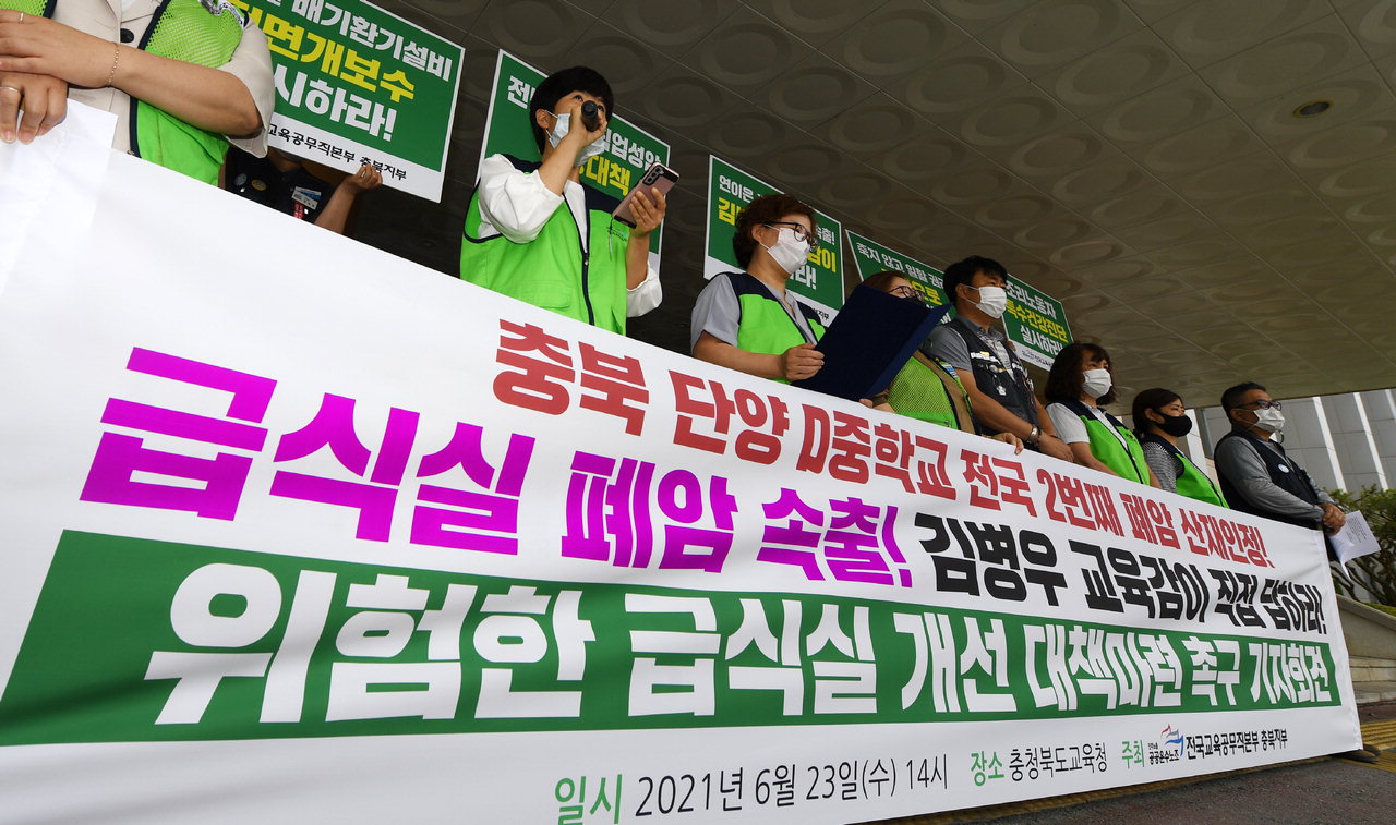전국교육공무직본부충북지부 회원들이 23일 충북도교육청 앞에서 기자회견을 열고 '위험한 급식실 개선대책 마련'을 촉구하고 있다. /김명년