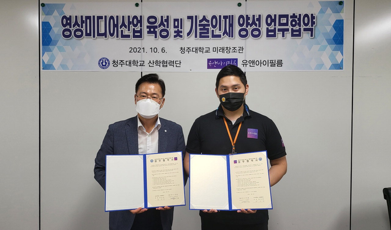 홍양희 청주대 산학협력단장(왼쪽)과 강경남 ㈜유앤아이필름 대표이사가 업무협약을 체결하고 기념촬영을 하고 있다.
