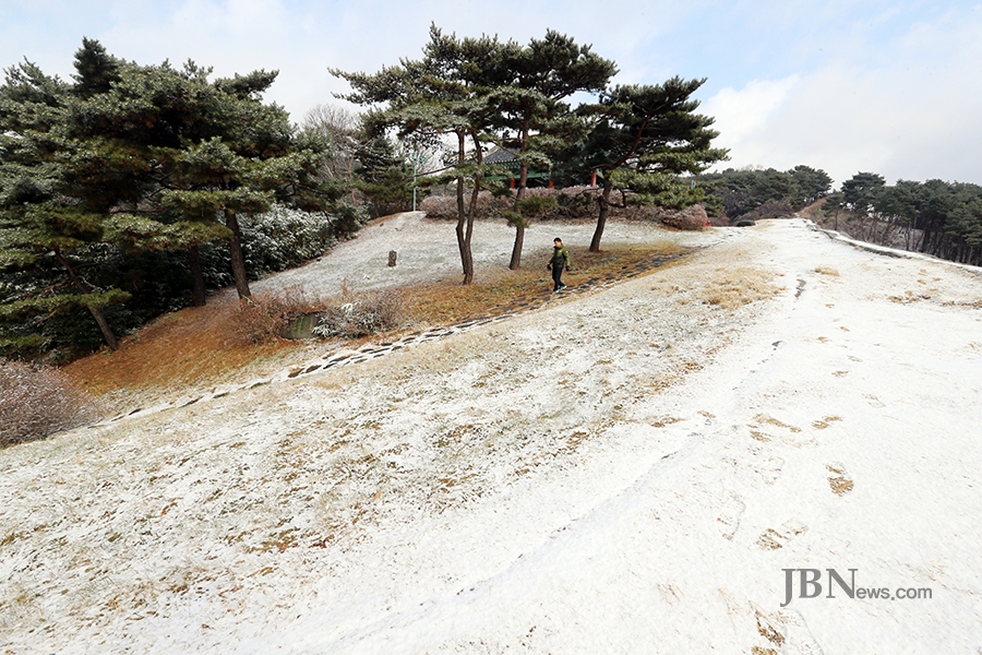 청주시 전역에 첫눈이 내린 23일 청주 상당산성을 찾은 시민들이 하얀 눈이 쌓인 등산로를 걷고 있다./신동빈