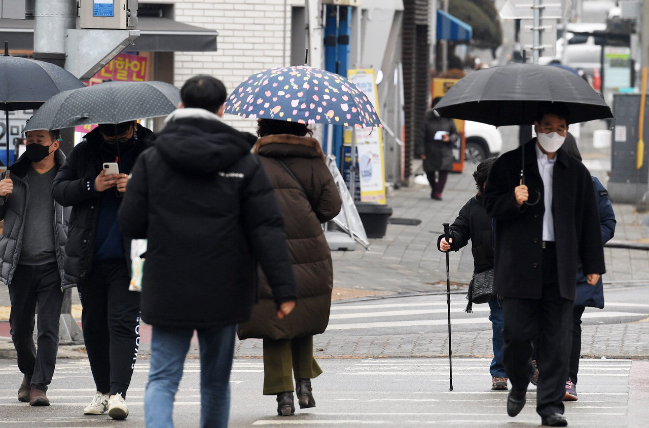 겨울비가 내린 21일 청주 사창사거리에서 시민들이 우산을 쓰고 횡단보도를 건너고 있다. 청주기상지청에 따르면 이날 청주지역 예상강수량은 5~20㎖다. /김명년